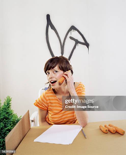 woman using a carrot as a telephone - costume rabbit ears stock pictures, royalty-free photos & images