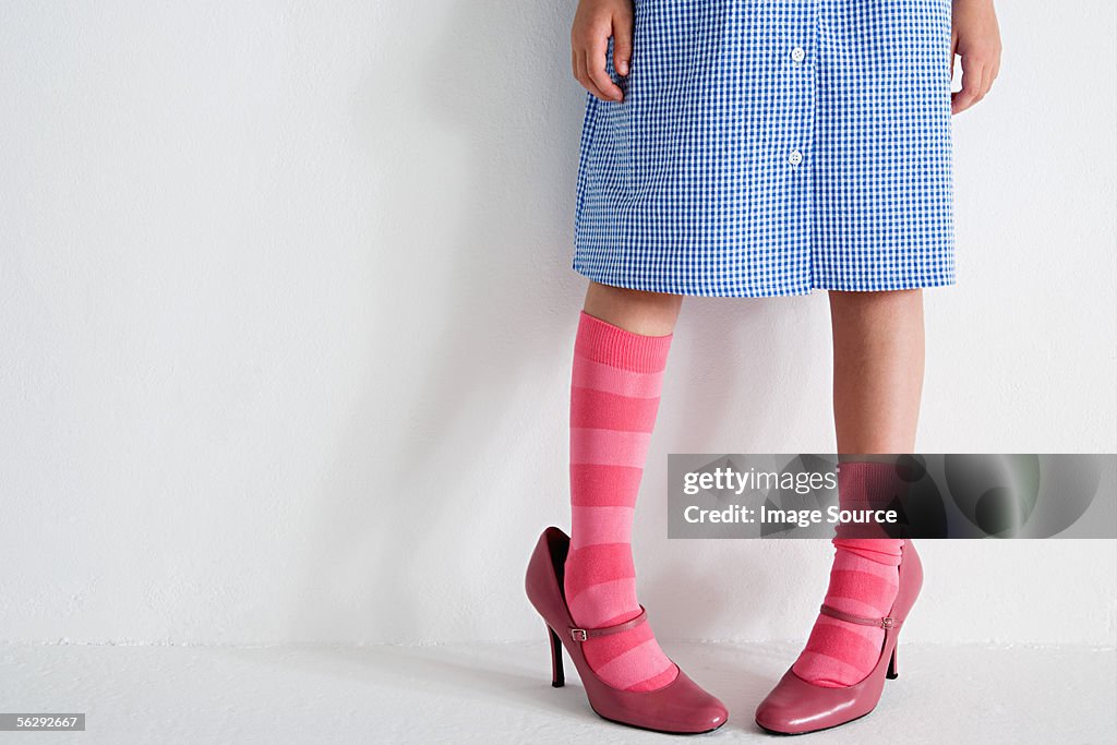 Girl wearing woman's shoes