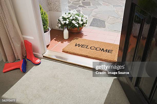 entrance to a house - welcome mat stock-fotos und bilder