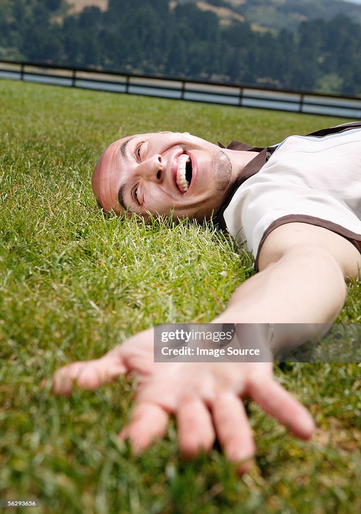 Happy man lying on the grass