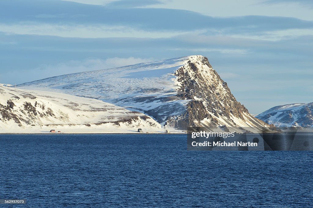 Norwegian Sea and island coast with buildings, Mageroya island, Finnmark County, Norway