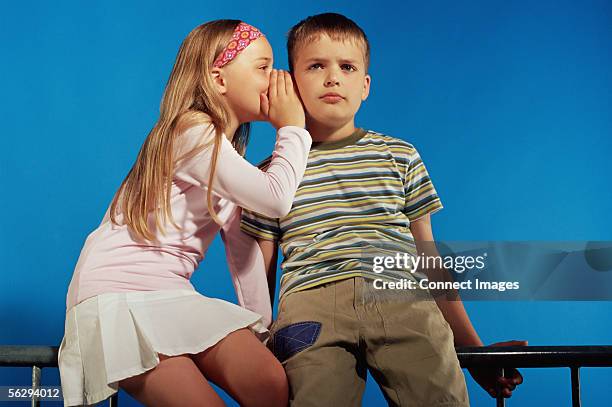 girl whispering to boy - whispering stock pictures, royalty-free photos & images