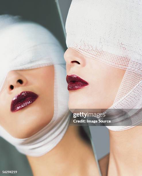 woman wearing lipstick and bandages - chirurgia plastica foto e immagini stock