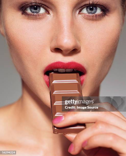 woman eating bar of chocolate - open chocolate bar stock pictures, royalty-free photos & images