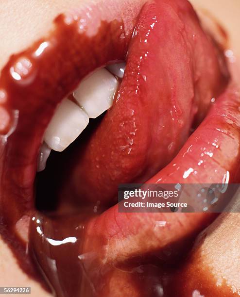 chocolate sauce spilling out of woman's mouth - seduzione foto e immagini stock