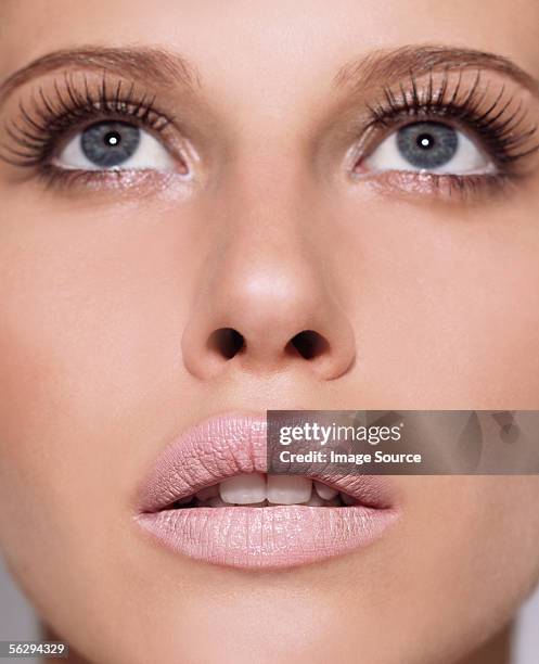 woman looking up - false eyelash stock-fotos und bilder