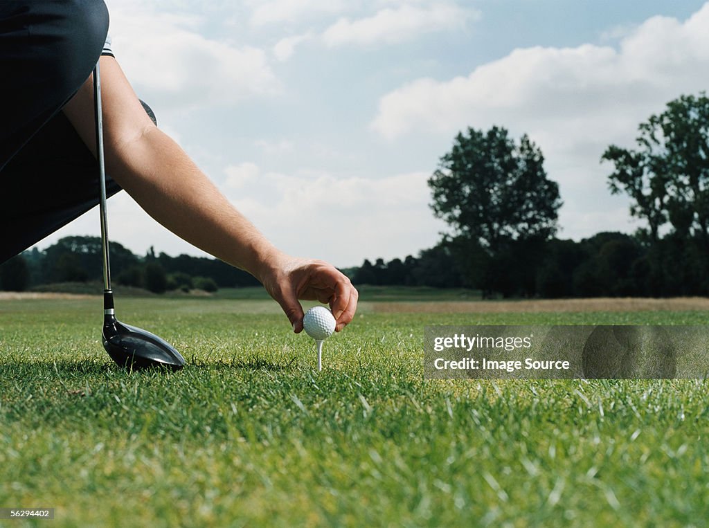 Placing a golf ball on the tee