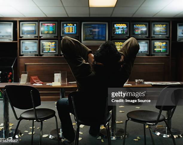 man sitting in a betting shop - sports betting stock-fotos und bilder
