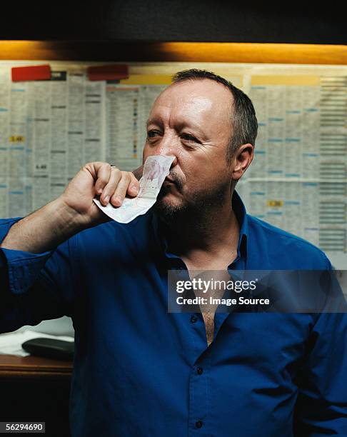 man smelling a twenty pound note - bookmakers stock pictures, royalty-free photos & images