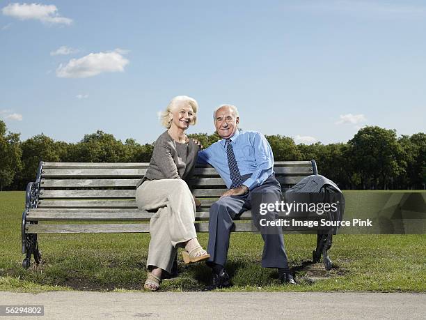 elderly couple on a park bench - parkbank stock-fotos und bilder