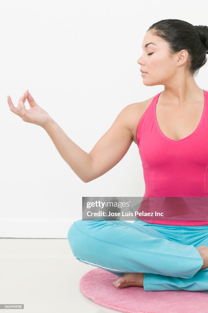 Teen girl meditating on floor mat