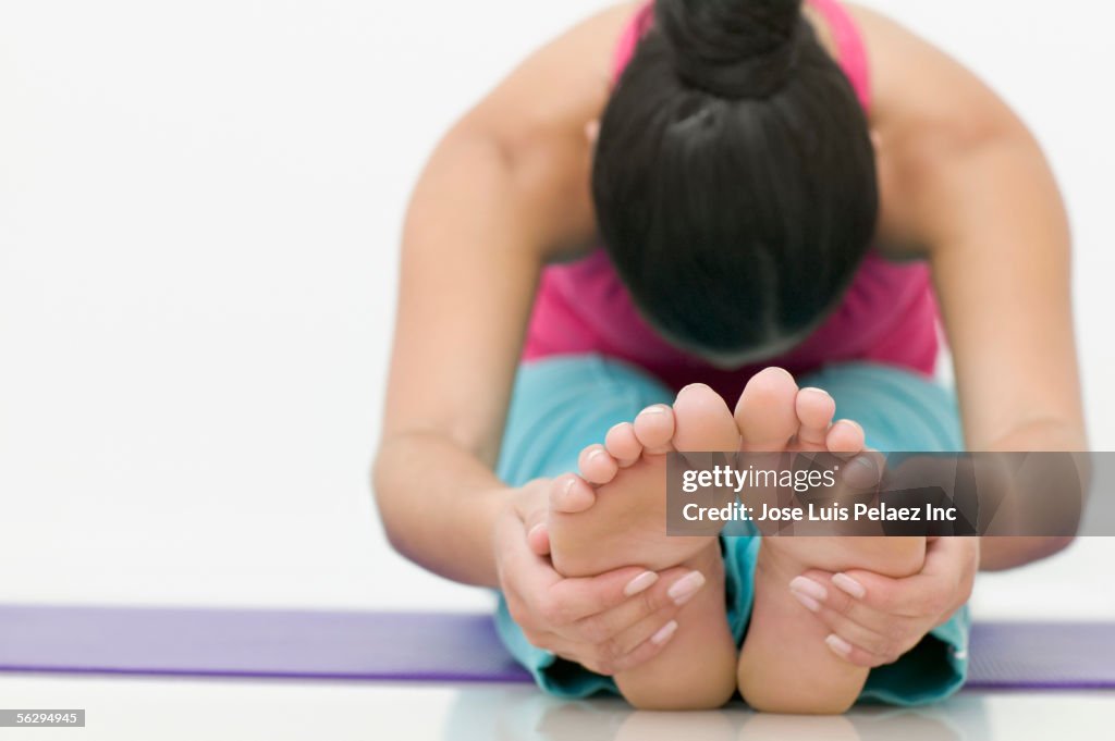 Teen girl stretching for her toes