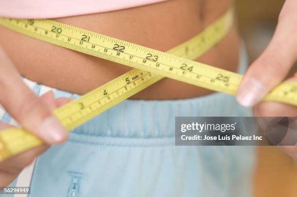 closeup of teen girl measuring her waist - degeneration stock pictures, royalty-free photos & images