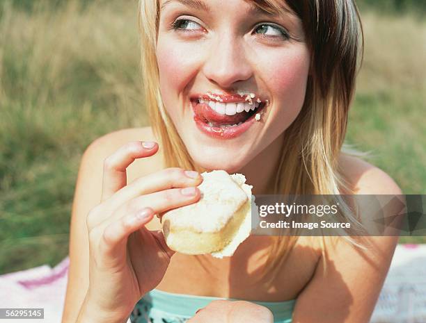 mujer comiendo una tarta - messy-eater-adult fotografías e imágenes de stock
