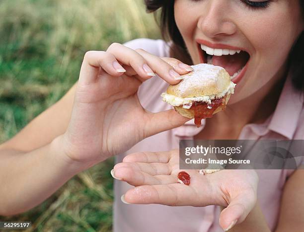 woman eating a scone - scone stock pictures, royalty-free photos & images