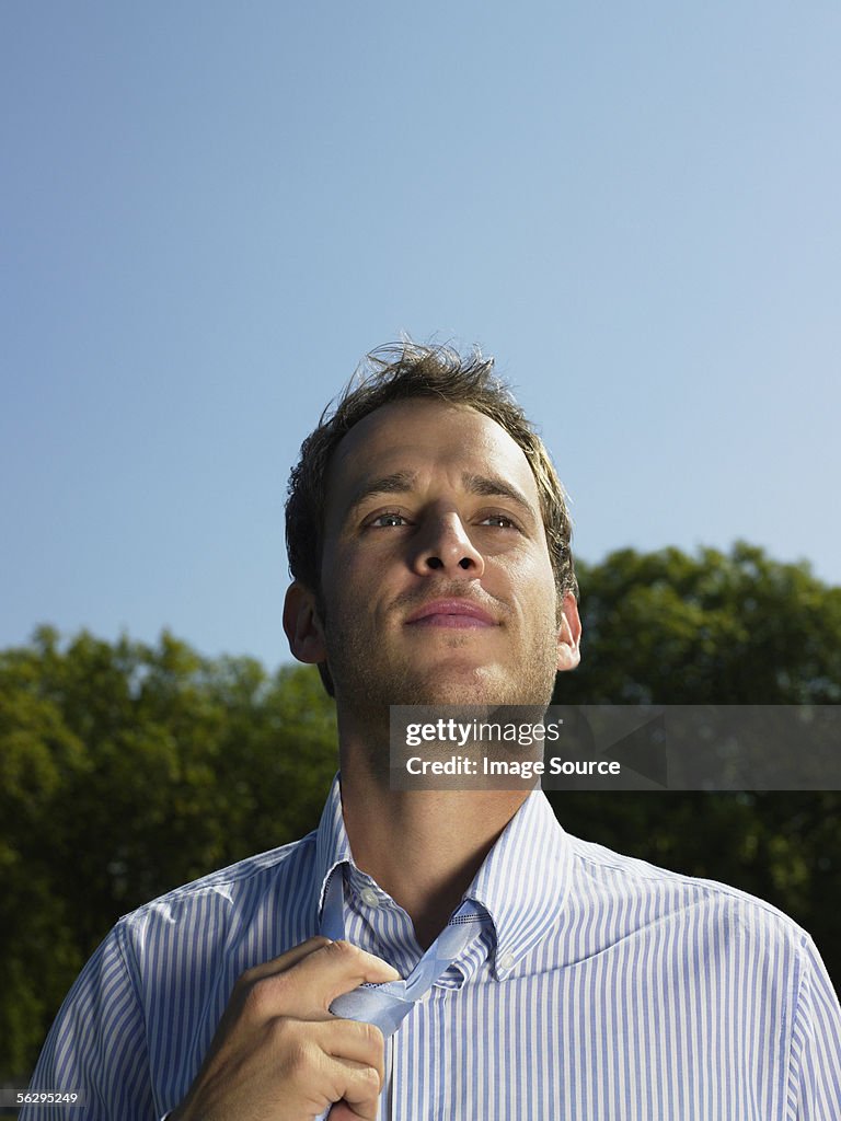 Office worker loosening his necktie