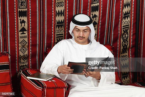 arab man reading a book - majlis stock pictures, royalty-free photos & images