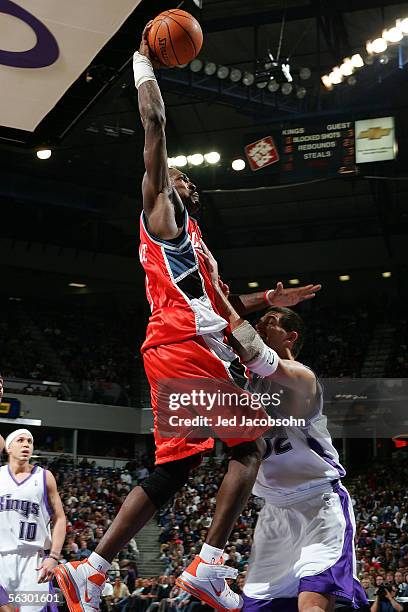 Gerald Wallace of the Charlotte Bobcats dunks over Brad Miller of the Sacramento Kings on November 29, 2005 at Arco Arena in Sacramento, California....