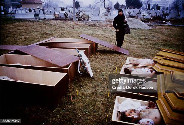 Open coffins in the cemetery in Timisoara in western Romania, shortly after the mass street protests at the start of the Romanian Revolution, circa...
