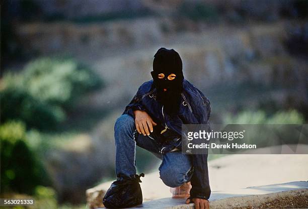 Palestinian combatants wearing disguises to hide their identity, seen here patrolling their village in the West Bank, occupied Palestinian...
