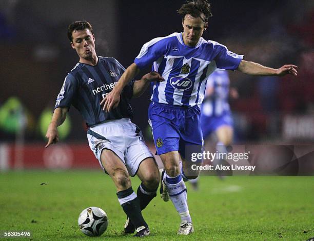 Andreas Johansson of Wigan Athletic is tackled by Scott Parker of Newcastle United during the Carling Cup fourth round match between Wigan Athletic...