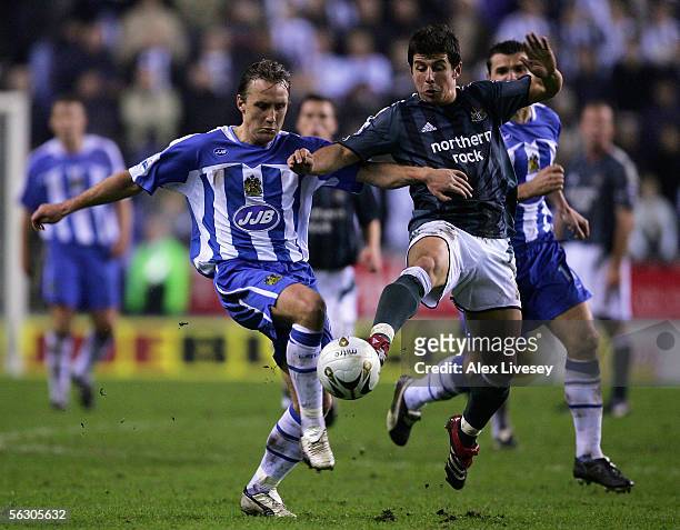 Andreas Johansson of Wigan Athletic holds off a challenge from Belozoglu Emre of Newcastle United during the Carling Cup fourth round match between...