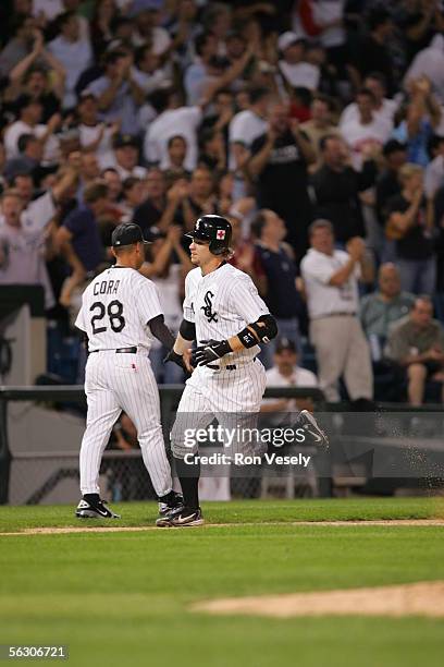 Joe Crede of the Chicago White Sox is greeted by third base coach Joey Cora during the game against the Cleveland Indians at U.S. Cellular Field on...