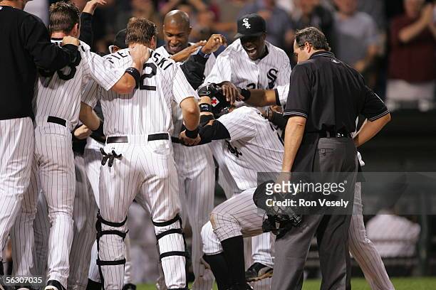 Joe Crede of the Chicago White Sox is mobbed by his teammates as he arrives at home after a walk-off home run against the Cleveland Indians at U.S....