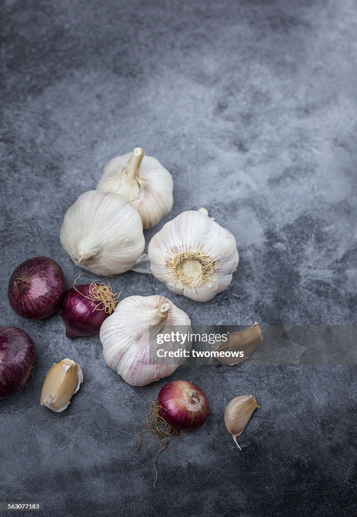 Garlic and shallots on rustic kitchen counter top.