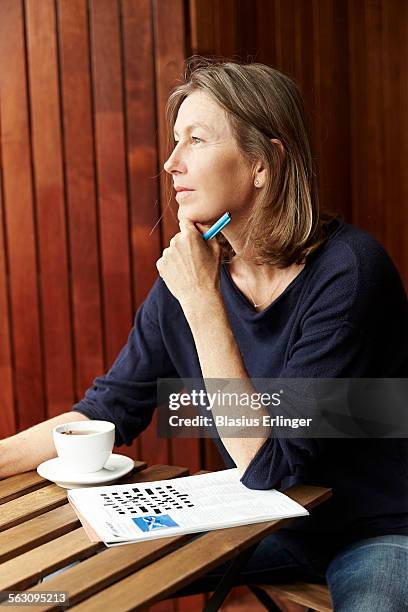 woman does crossword - kruiswoordpuzzel stockfoto's en -beelden