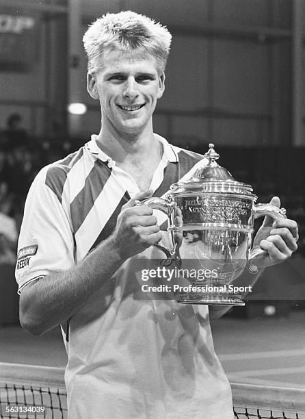 Portrait of British tennis player Andrew Castle holding his trophy at the National Tennis Championships, 1987.