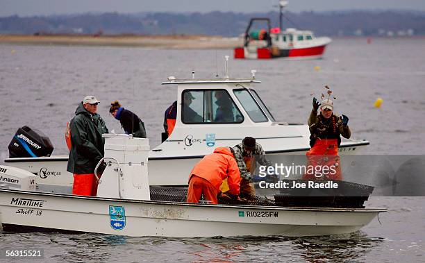 Personnel with the Rhode Island Department of Environmental Management and the National Oceanic and Atmospheric Administration release oysters into...