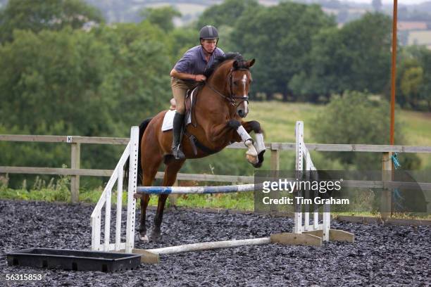 Young man schools a Dutch Warmblood horse, Oxfordshire, England.