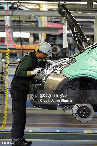 Employees of Toyota Motor Corporation work during the assembly process at the company's Takaoka Plant on December 2, 2005 in Toyota, Aichi...