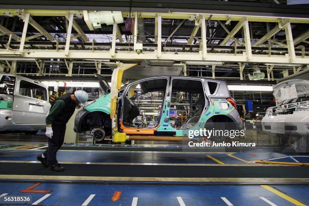 Employees of Toyota Motor Corporation work during the assembly process at the company's Takaoka Plant on December 2, 2005 in Toyota, Aichi...