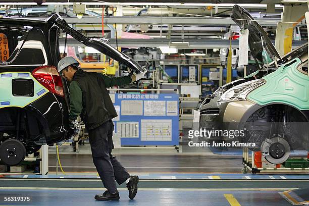 Employees of Toyota Motor Corporation work during the assembly process at the company's Takaoka Plant on December 2, 2005 in Toyota, Aichi...