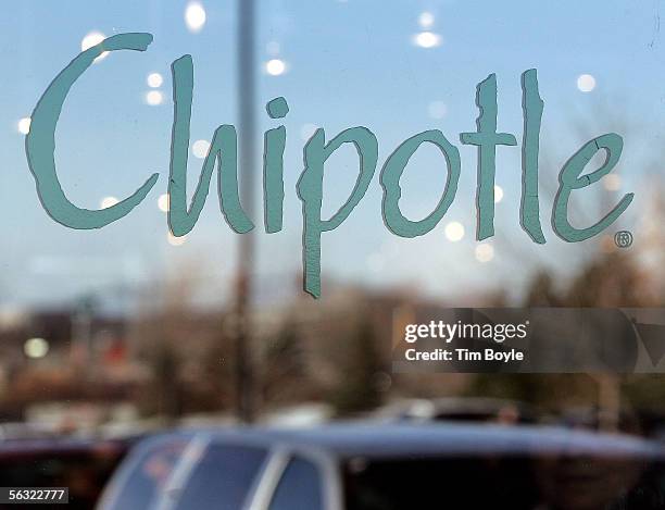 Patron's face, bottom right, is slightly visible beyond signage through a window of a Chipotle restaurant December 2, 2005 in Glenview, Illinois....