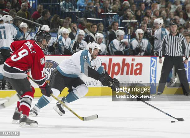 Joe Thornton of the San Jose Sharks, in his first game with the Sharks, reaches for the puck against Tim Connolly of the Buffalo Sabres on December...
