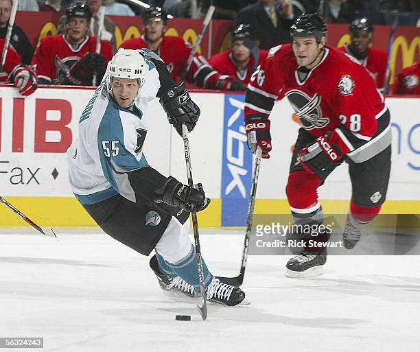Grant Stevenson of the San Jose Sharks skates with the puck ahead of Paul Gaustad of the Buffalo Sabres on December 2, 2005 at HSBC Arena in Buffalo,...