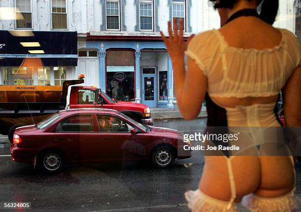 Traffic drives past the window where Nikki Hunt models lingerie in the front of Spellbound, a lingerie store, December 2, 2005 in Augusta, Maine....