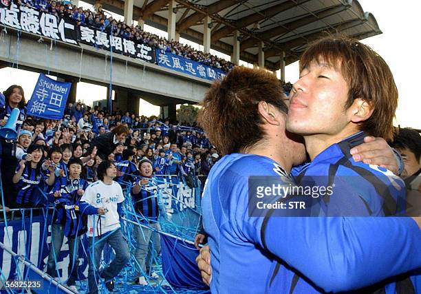 Gamba Osaka's ace striker Masashi Oguro hugs a fan after winning against Kawasaki Frontale in the J-League championship at Todoroki stadium in...