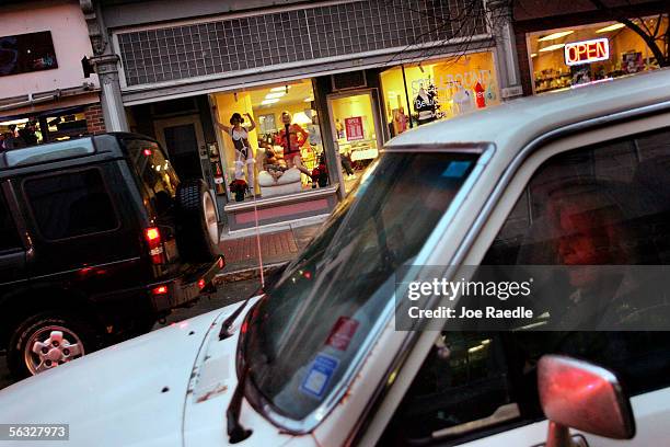Vehicle drives past the window where Nikki Hunt and Tara Manns model lingerie in the front of Spellbound, a lingerie store, December 2, 2005 in...