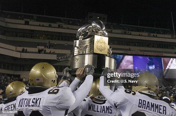 In this handout provided by the U.S. Navy, Navy players hold the Commander-in-Chief's Trophy following a 42-23 victory over the Black Knights of Army...