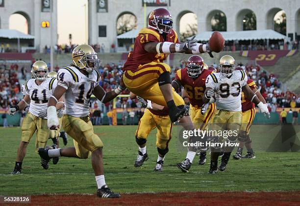 LenDale White of the USC Trojans jumps in the end zone for a touchdown against Tom Malone and Lawrence Miles of the UCLA Bruins December 3, 2005 at...