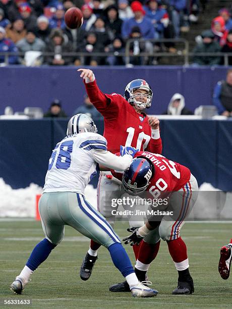 Quarterback Eli Manning of the New York Giants throws a pass as teammate Shaun O'Hara blocks linebacker Scott Shanle of the Dallas Cowboys during...