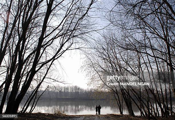 Couple looks across the Potomac River into Virgina 04 December 2005 at Edwards Ferry in the Chesapeake and Ohio Canal National Historical Park in...