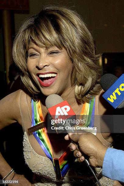 Singer Tina Turner laughs as she speaks to a reporter while on the red carpet at the Kennedy Center December 4, 2005 in Washington, DC. Redford was...