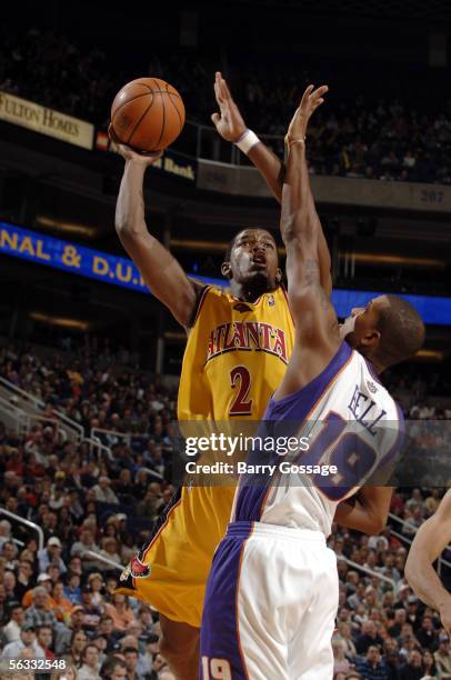 Joe Johnson of the Atlanta Hawks shoots over the block of Raja Bell of the Phoenix Suns in an NBA game played on December 4 at America West Arena in...