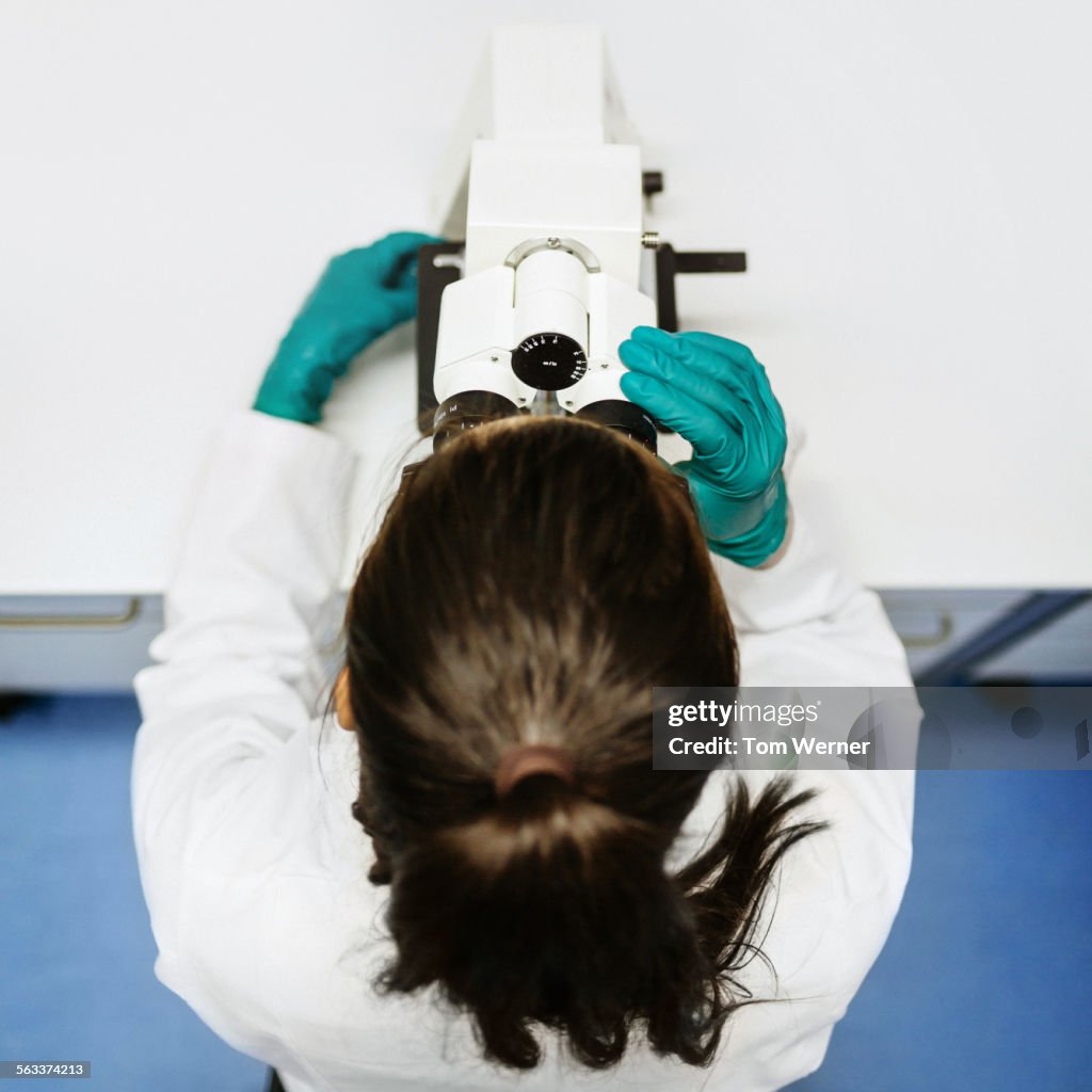 Female Scientist On Microscope