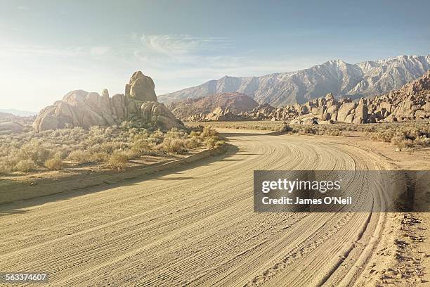 dirt road in rocky landscape - alabama hills stock-fotos und bilder